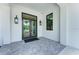 Modern building entrance with double doors and gray brick pavers at 5655 Pipers Waite # 27, Sarasota, FL 34235