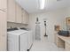 Laundry room with washer, dryer, and built-in cabinets at 5655 Pipers Waite # 27, Sarasota, FL 34235