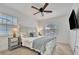 King-size bed, TV, and ceiling fan in bright bedroom at 567 Venice Ln, Sarasota, FL 34242