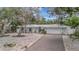 Single-story house featuring white exterior, brick driveway, and landscaping at 567 Venice Ln, Sarasota, FL 34242