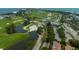 Aerial view showing a golf course, clubhouse, and waterfront at 601 Weston Pointe Ct, Longboat Key, FL 34228