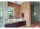 Spa-like bathroom with soaking tub, walk-in shower, and marble tile at 601 Weston Pointe Ct, Longboat Key, FL 34228