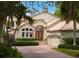 Two-story house with brick driveway, lush landscaping, and a three-car garage at 601 Weston Pointe Ct, Longboat Key, FL 34228