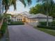 Two-story house with brick driveway, lush landscaping, and a three-car garage at 601 Weston Pointe Ct, Longboat Key, FL 34228