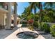 Relaxing hot tub with tropical landscaping and a view of the pool at 601 Weston Pointe Ct, Longboat Key, FL 34228