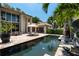 Resort-style pool with spacious patio, lush landscaping, and outdoor seating at 601 Weston Pointe Ct, Longboat Key, FL 34228