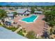 Aerial view of a community pool area with a swimming pool, hot tub, lounging chairs, and clubhouse at 603 Chestnut Ln # 90, Englewood, FL 34223