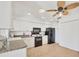 Bright kitchen with white cabinets, black appliances, tile floors, and modern ceiling fan at 603 Chestnut Ln # 90, Englewood, FL 34223