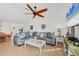 Bright living room with tile flooring, ceiling fan, large sectional, and beach view from the windows at 603 Chestnut Ln # 90, Englewood, FL 34223