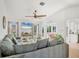 Bright living room with tile flooring, ceiling fan, large sectional, and beach view from the windows at 603 Chestnut Ln # 90, Englewood, FL 34223