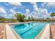 Sparkling swimming pool with clear blue water, surrounded by lounge chairs and lush landscaping at 603 Chestnut Ln # 90, Englewood, FL 34223