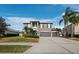 Two-story house with gray siding, three-car garage, and palm trees at 6150 42Nd Street E Cir, Bradenton, FL 34203