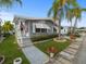 Gray manufactured home with steps, landscaping, and American flag at 62 Pelican S Dr, Oldsmar, FL 34677