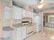 View of kitchen with white cabinets, range, and refrigerator at 62 Pelican S Dr, Oldsmar, FL 34677