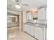 Kitchen boasts white cabinets, gray countertops, and a dishwasher at 62 Pelican S Dr, Oldsmar, FL 34677