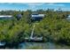 Aerial view of house and dock, surrounded by lush greenery at 716 Tropical Cir, Sarasota, FL 34242