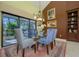 Elegant dining area with glass-top table, blue chairs and window views at 716 Tropical Cir, Sarasota, FL 34242