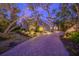 House exterior at dusk, showcasing landscaping and a brick driveway at 716 Tropical Cir, Sarasota, FL 34242