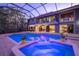 Inviting pool and spa with a screened enclosure, showing the house in the background at 716 Tropical Cir, Sarasota, FL 34242