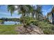 Landscaped backyard with a walkway leading to a lake at 7349 Windemere Ln, University Park, FL 34201