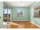 Light and airy bedroom with wood flooring and sliding glass door to patio at 7432 39Th E Ct, Sarasota, FL 34243