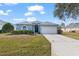 One-story house with light blue exterior, two-car garage, and well-maintained lawn at 7432 39Th E Ct, Sarasota, FL 34243