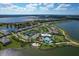 Aerial view of a beautiful community with a lake, pool, and tennis courts at 7876 Grande Shores Dr, Sarasota, FL 34240