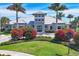 Community clubhouse with lush landscaping and palm trees at 7876 Grande Shores Dr, Sarasota, FL 34240