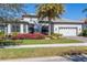 Two-story home with palm tree, manicured landscaping, and white garage door at 7876 Grande Shores Dr, Sarasota, FL 34240