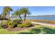 Landscaped lakefront yard with lush greenery and bird feeder at 7876 Grande Shores Dr, Sarasota, FL 34240