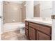 Bathroom featuring a tub and shower, with light beige colored wall tile and a wood vanity at 11715 Summer Springs Dr, Riverview, FL 33579