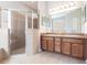 Bathroom featuring double vanity sinks, shower stall, and large mirror at 11715 Summer Springs Dr, Riverview, FL 33579