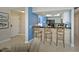 Kitchen with breakfast bar, three stools, and blue accent wall at 1228 Siesta Bayside Dr # 1228-C, Sarasota, FL 34242