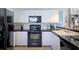 Well-equipped kitchen with black appliances and white cabinets at 1228 Siesta Bayside Dr # 1228-C, Sarasota, FL 34242