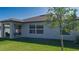 Single-story home with covered patio, grassy backyard, and mature tree at 13608 Sunset Sapphire Ct, Parrish, FL 34219