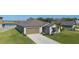 One-story home with brown garage door, landscaping, and a view of a lake at 13608 Sunset Sapphire Ct, Parrish, FL 34219
