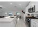 Modern kitchen featuring white cabinets, a large island, and a view to the backyard at 13608 Sunset Sapphire Ct, Parrish, FL 34219