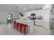 Modern kitchen with white cabinets, quartz countertops, and red barstools at 13608 Sunset Sapphire Ct, Parrish, FL 34219