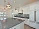 Spacious kitchen with white cabinets, large island, and copper pendant lighting at 13619 Old Creek Ct, Parrish, FL 34219