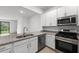 Modern kitchen with white cabinets, granite countertops, and stainless steel appliances at 14824 Lyla Ter, Bradenton, FL 34211