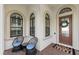 Front entry with seating area and decorative wreath at 15608 Leven Links Pl, Lakewood Ranch, FL 34202