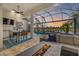 Outdoor kitchen, pool, and seating area with sunset view at 15608 Leven Links Pl, Lakewood Ranch, FL 34202
