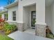 Close up of the front entrance with stone accents and gray door at 2219 Greenley Rd, North Port, FL 34286