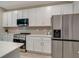 Modern kitchen features stainless steel appliances and white shaker cabinets at 2219 Greenley Rd, North Port, FL 34286