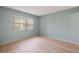 Light-filled bedroom with wood-look floors and a large window at 25100 Sandhill Blvd # 102, Punta Gorda, FL 33983