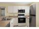 Galley style kitchen with stainless steel appliances at 25100 Sandhill Blvd # 102, Punta Gorda, FL 33983