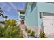 Beautiful blue home featuring stone accents, lush tropical landscaping, and an inviting pathway to the front door at 262 Island Cir, Sarasota, FL 34242