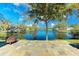 Backyard with stone patio offers a serene water view, creating an ideal outdoor relaxation and entertainment space at 309 South Dr, Nokomis, FL 34275