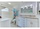Bright bathroom features a double sink vanity, modern lighting, and a shower with stylish fixtures at 309 South Dr, Nokomis, FL 34275