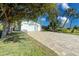 Charming home featuring a two-car garage and a brick-paved driveway, framed by mature trees and lush landscaping at 309 South Dr, Nokomis, FL 34275